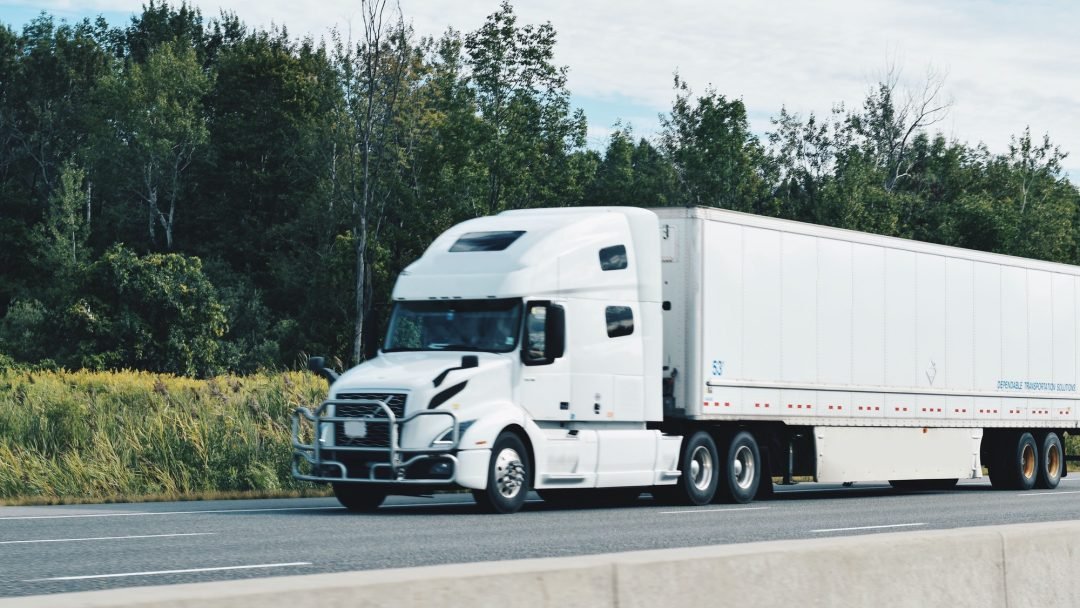 all-white-tractor-trailer-driving-on-a-highway.jpg